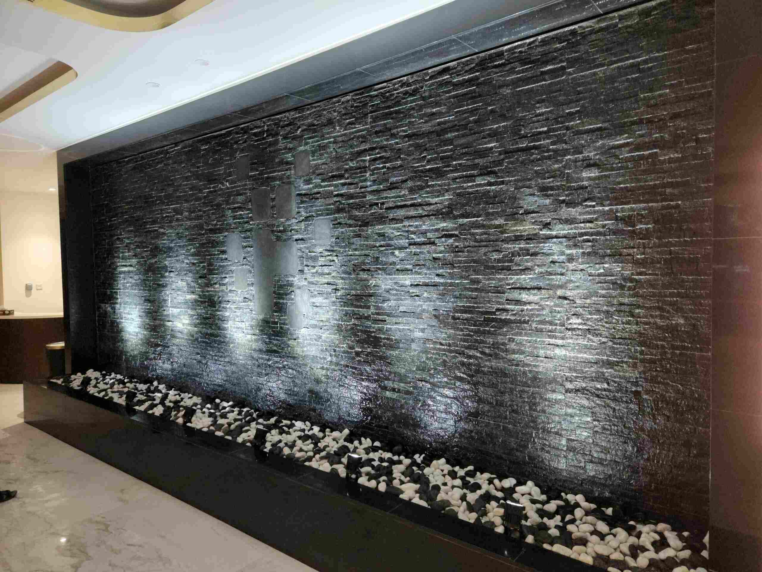 a large black wall with white flowers on it - landscaping services dubai