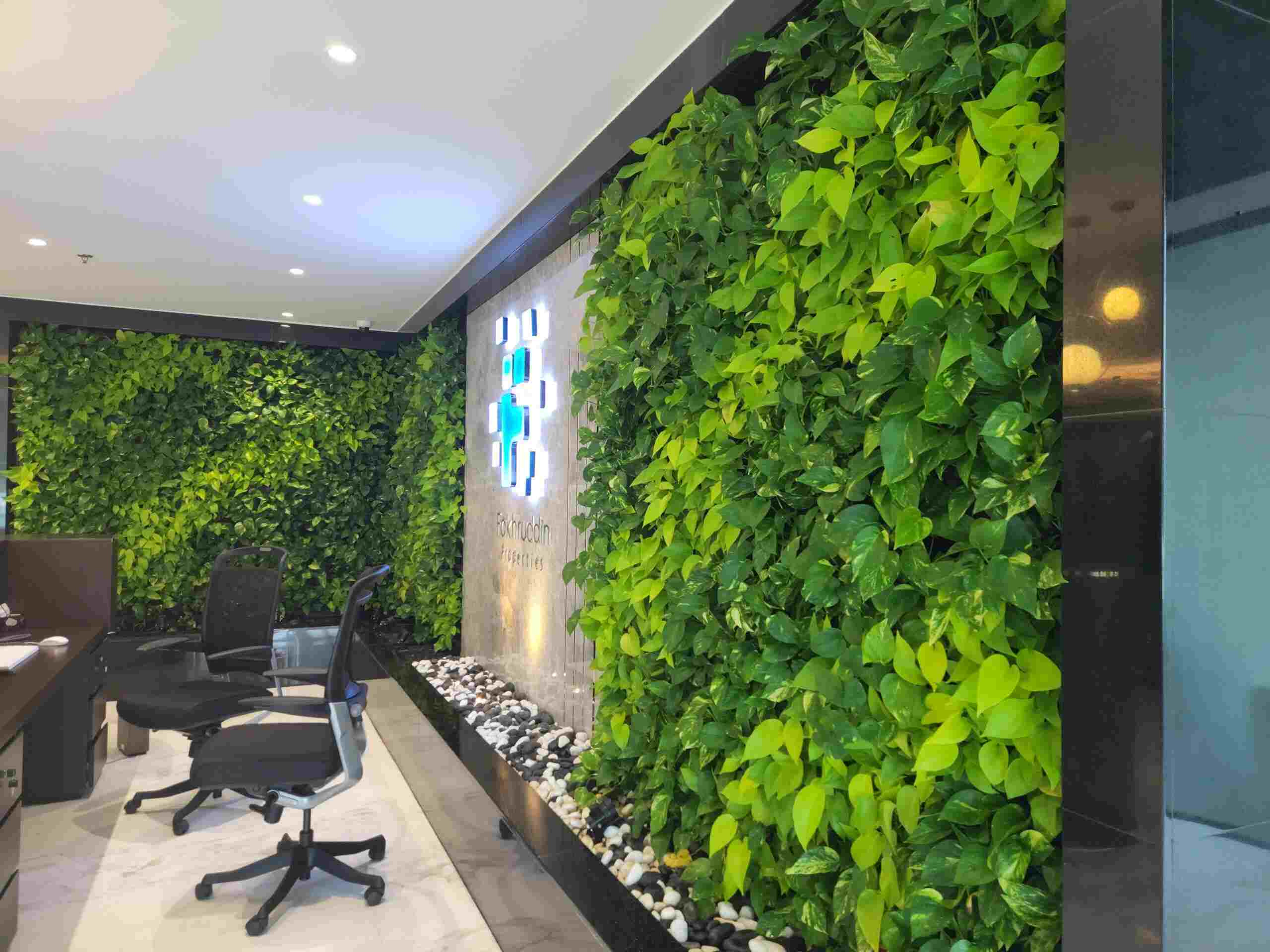 an office with a green wall and a computer desk - landscaping services Dubai