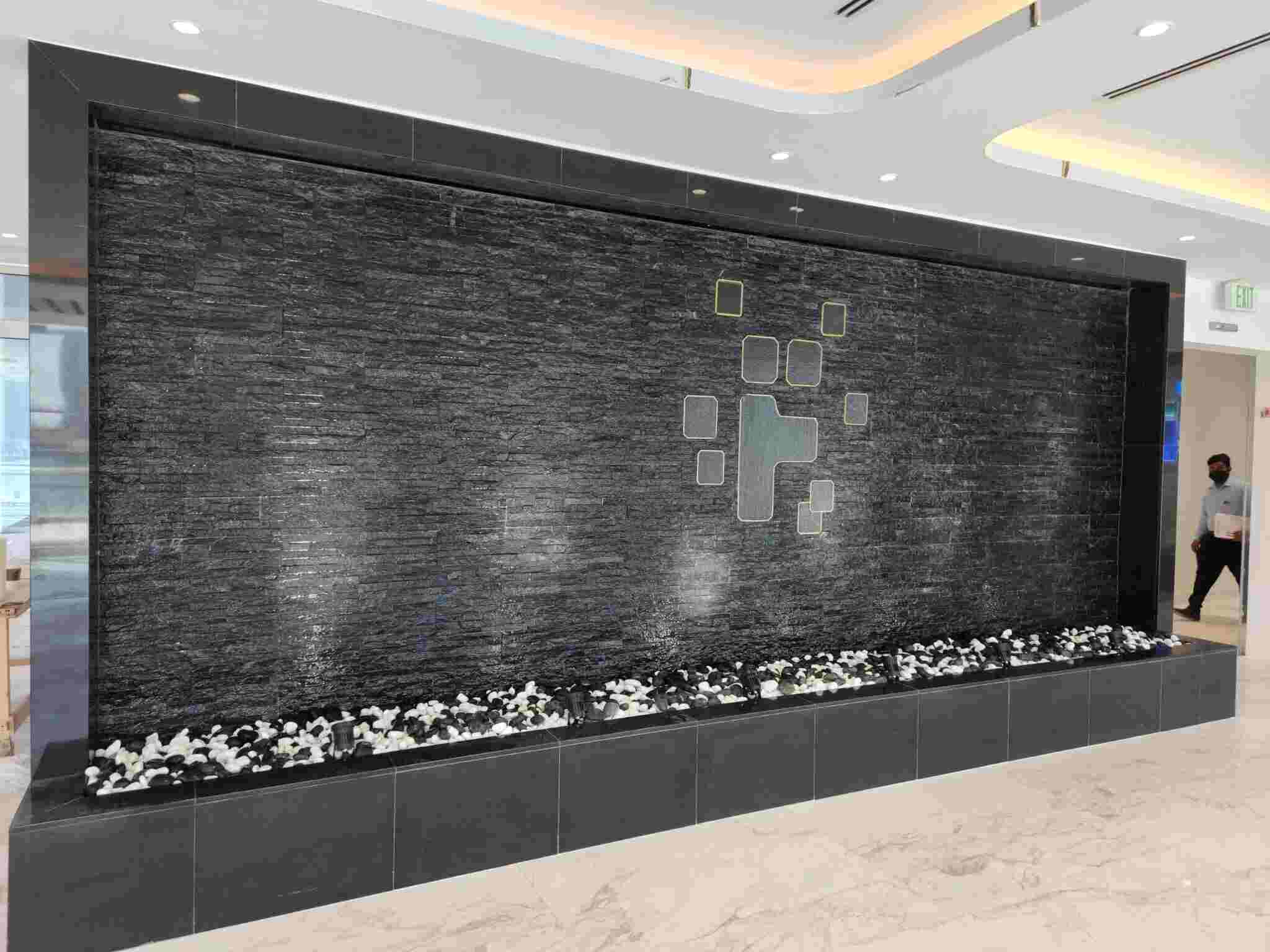 a large wall fountain in a lobby - landscaping services dubai