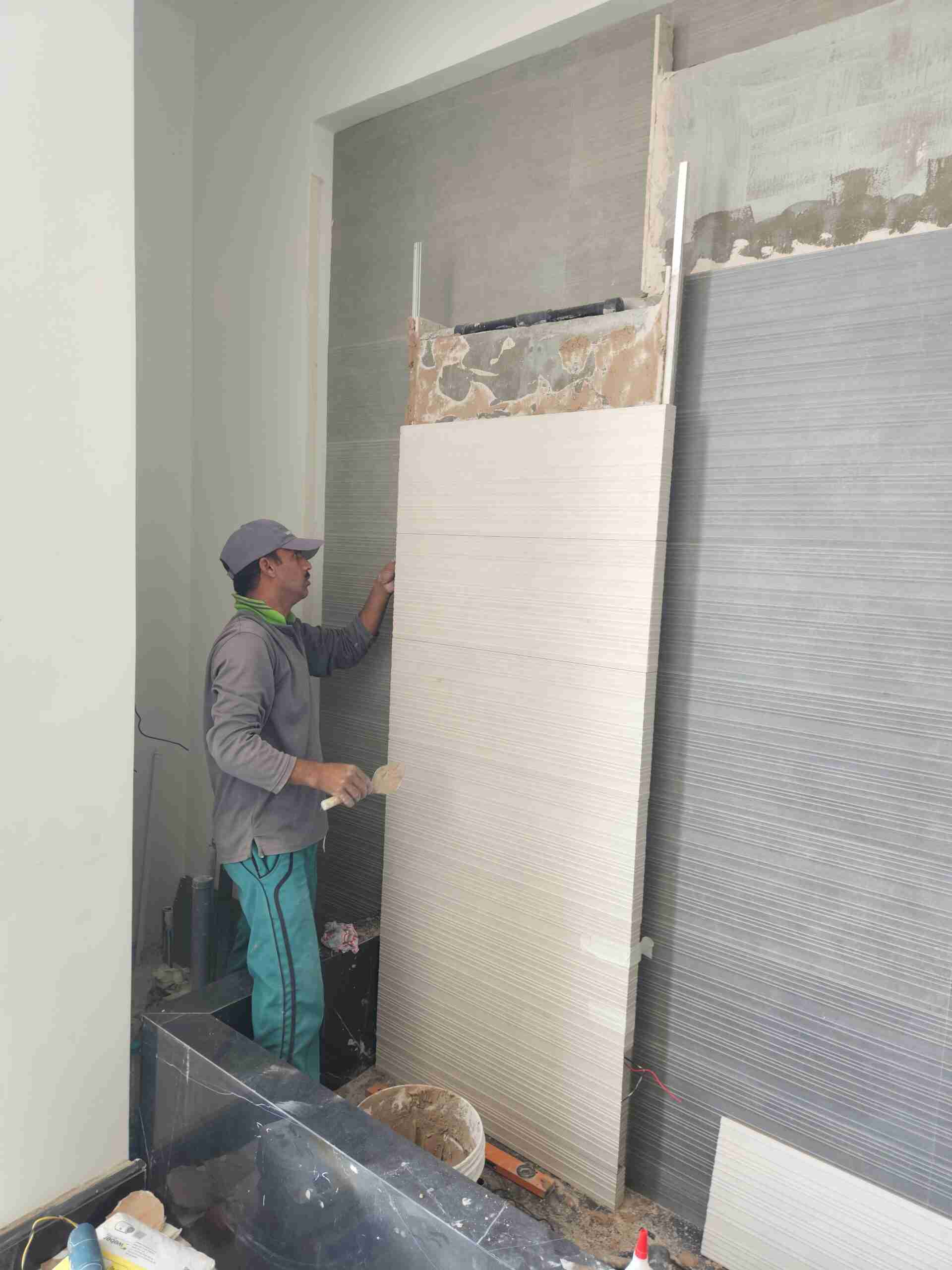 a man is painting a wall in a room - Home Decore - landscaping services dubai