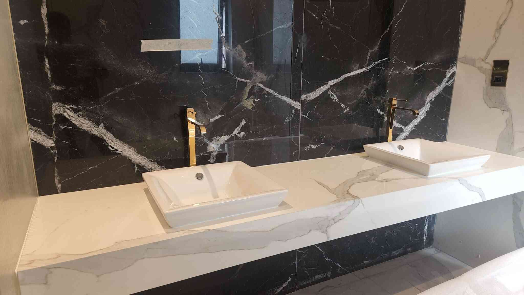 a bathroom with a marble counter top and two sinks - landscaping dubai uae