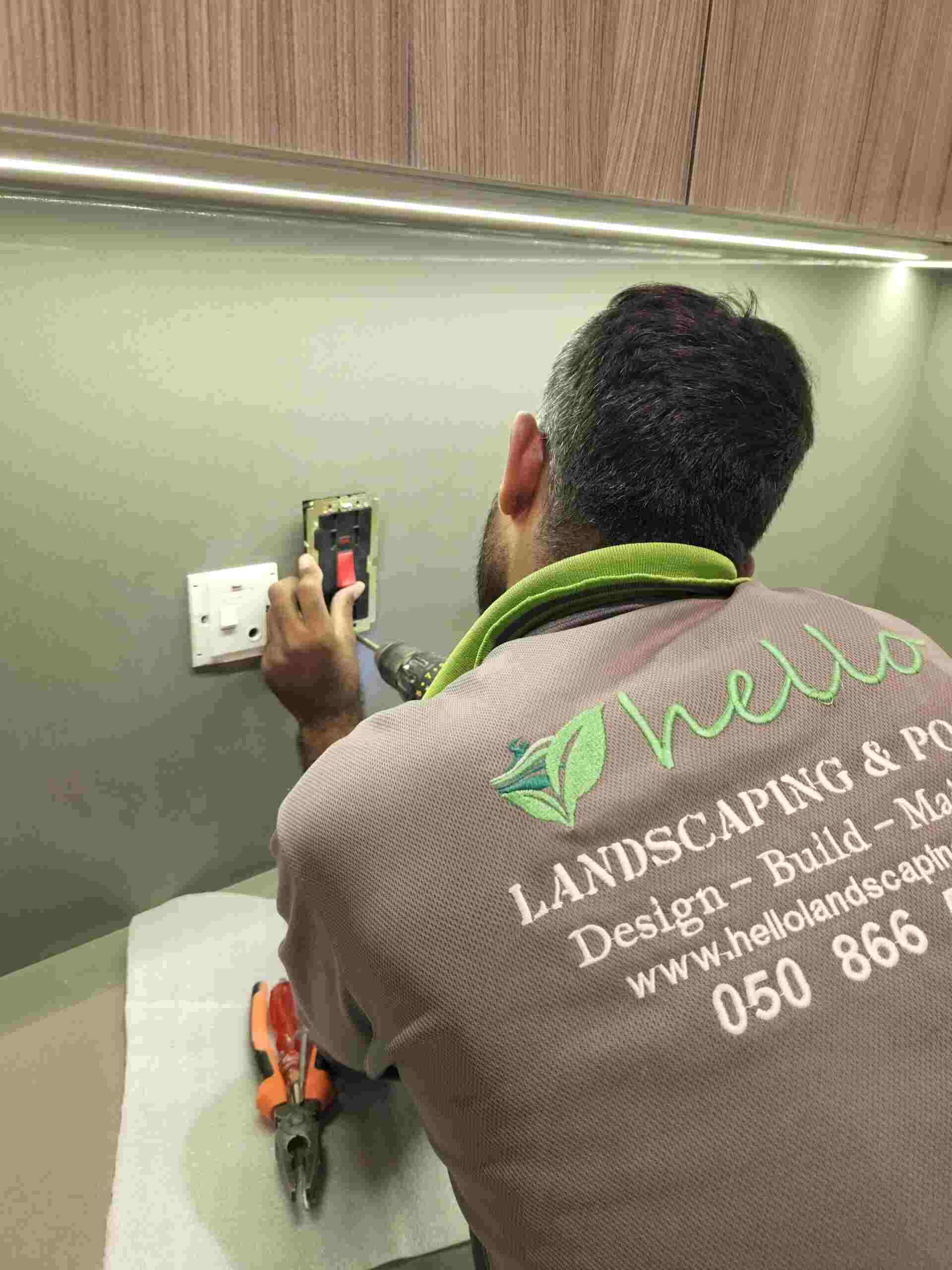 Man fixing kitchen outlet - Construction Company in Dubai UAE